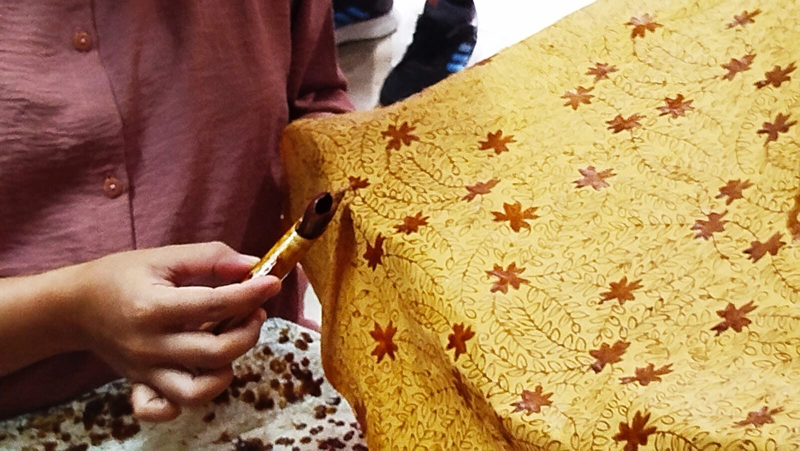 Seorang pembatik tengah menorehkan malam panas menggunakan canting pada selembar kain. Di balik setiap motif batik tersimpan proses panjang yang membutuhkan ketelitian, kesabaran, dan keterampilan yang diwariskan dari generasi ke generasi. (Foto: Urbanvibes/R Indriani)